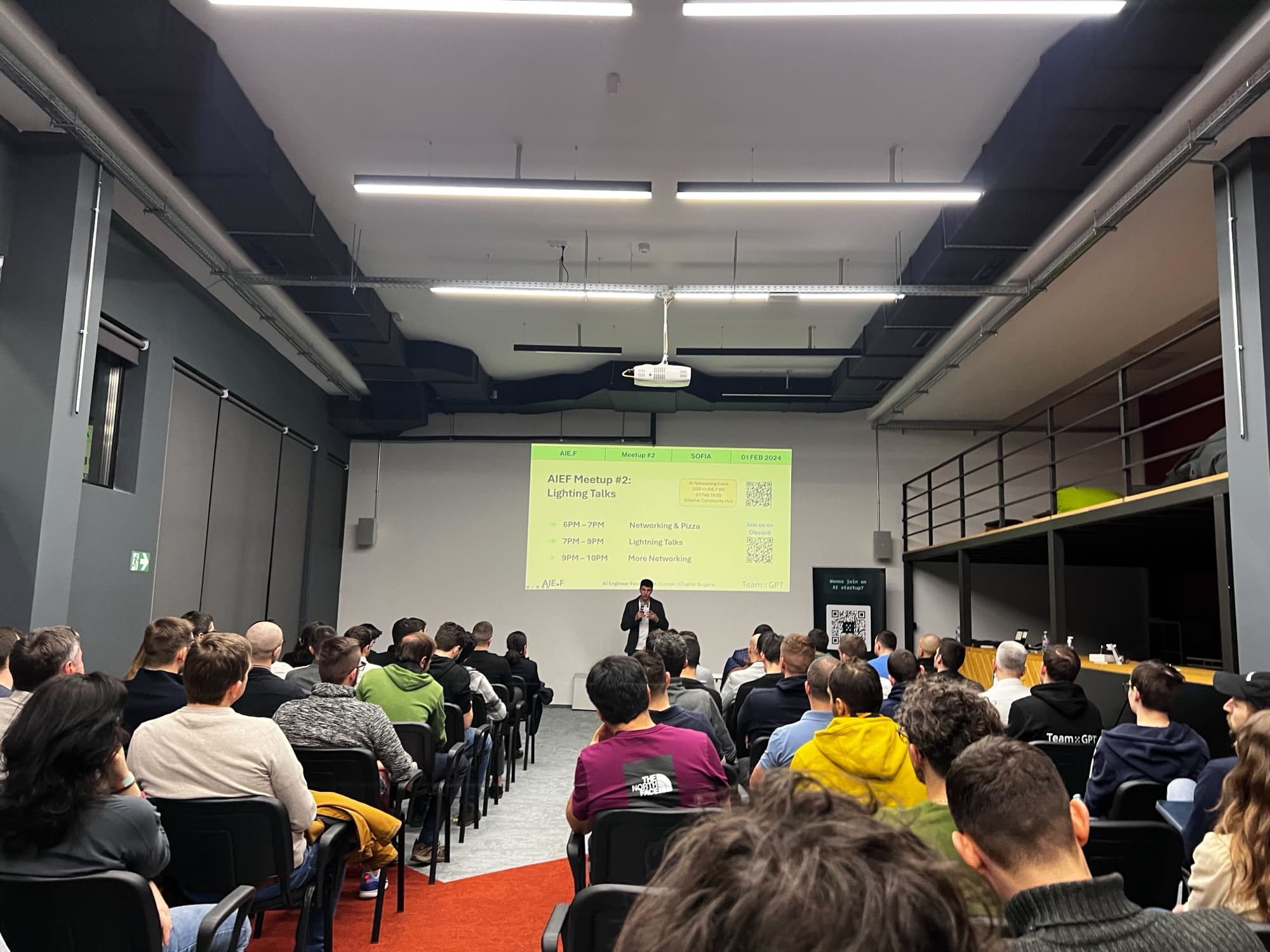 A speaker on stage in front of a full room